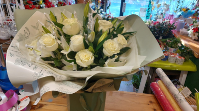 Winter wonderland - A beautiful handtied arrangement of stunning white roses and white lily finished with snow covered branches